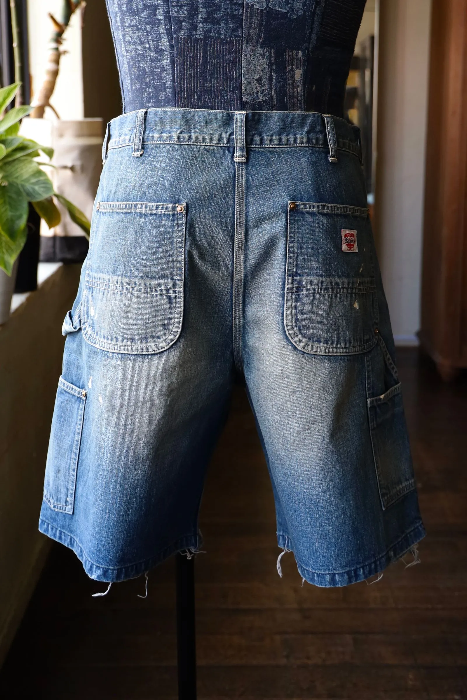 SAINT Mxxxxxx DOUBLE KNEE SHORTS/BLU Knee patches splashed with ink and water-splashed denim shorts. Denim blue S-XL. Custom-woven and dyed denim fabric with clear texture. Heavy-wash water-fading treatment to create local mottled fading/hole effects. Artificial distressing to simulate natural wearing marks. VINTAGE sense. Original consistent damage treatment. Hand-splashed ink and paint. Original consistent wash mark/pocket mark. Double knee patch. Rivet reinforcement. Improve functionality while enhancing design
